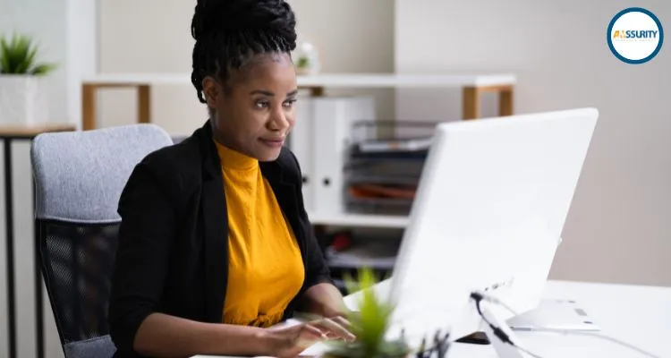 A smiling person using a computer to indicate a happy employee enjoying wiba insurance in kenya b